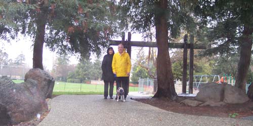 Sheba with Dr. Jim and Nancy under the trees